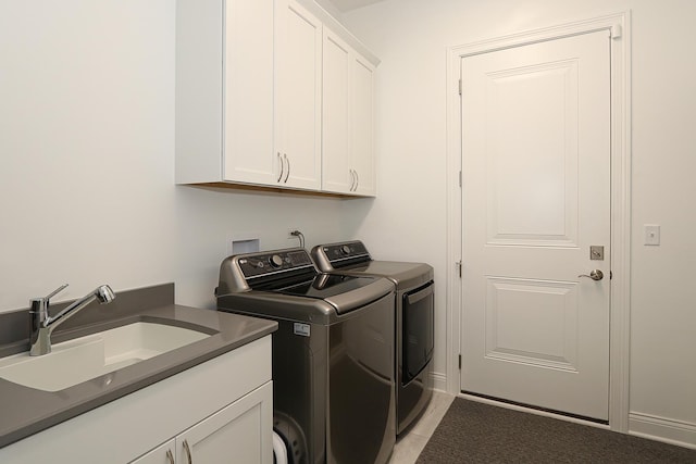 laundry room with washing machine and clothes dryer, sink, light tile patterned floors, and cabinets