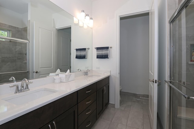 bathroom featuring tile patterned flooring, vanity, toilet, and walk in shower