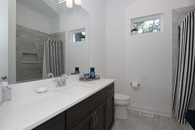 bathroom featuring curtained shower, tile patterned flooring, vanity, and toilet