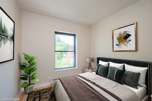 bedroom with a baseboard radiator and hardwood / wood-style floors