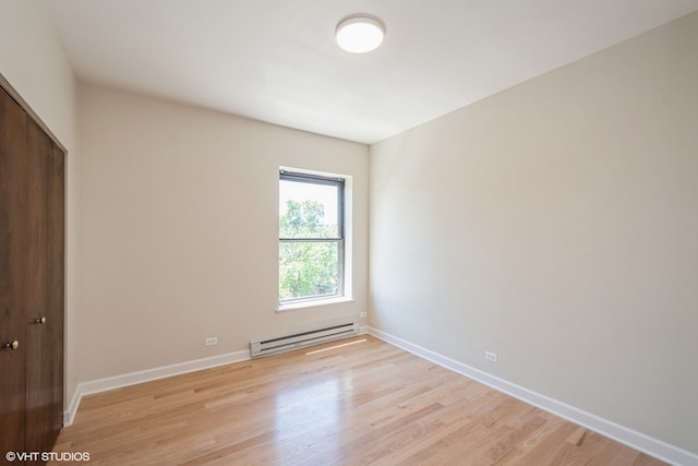 spare room with light hardwood / wood-style flooring and a baseboard heating unit