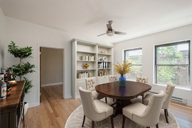 dining room with a baseboard radiator, ceiling fan, and light hardwood / wood-style flooring