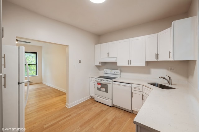 kitchen with light wood-type flooring, sink, white appliances, and white cabinetry