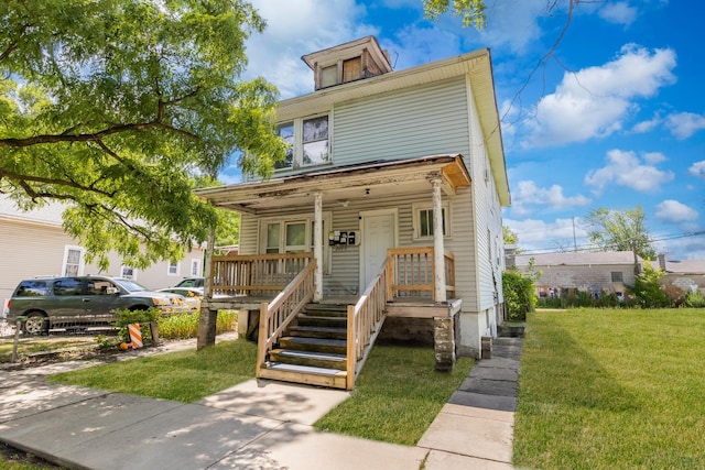 american foursquare style home featuring a front yard and covered porch