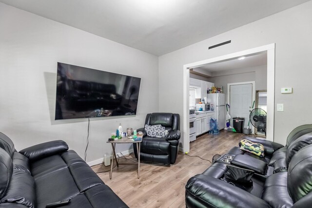 living area featuring light wood-type flooring and baseboards