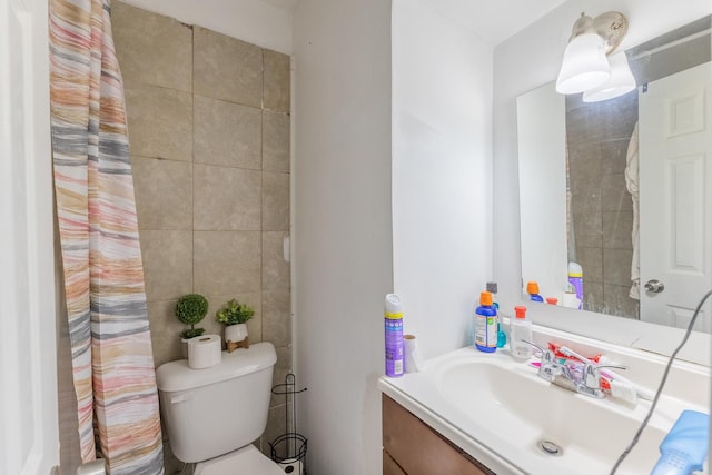 bathroom with toilet, tile walls, and vanity