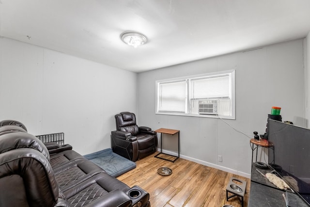 living room with light wood-style floors, cooling unit, and baseboards