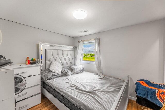 bedroom with light wood-type flooring and visible vents