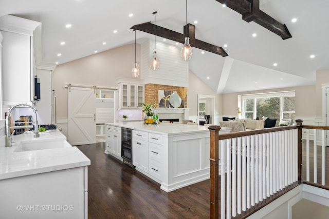 kitchen featuring pendant lighting, high vaulted ceiling, beam ceiling, white cabinetry, and beverage cooler