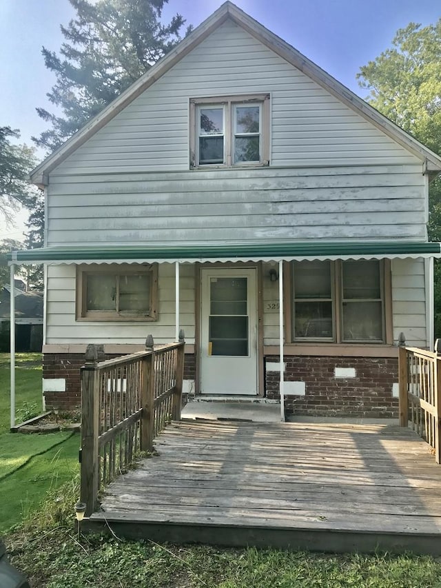 rear view of property featuring a wooden deck