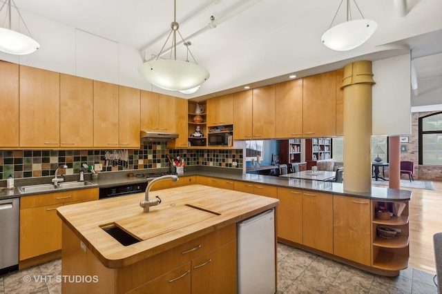 kitchen featuring wood counters, sink, and a kitchen island with sink