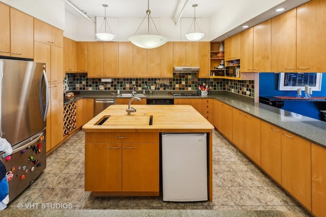 kitchen featuring an island with sink, appliances with stainless steel finishes, backsplash, and wood counters