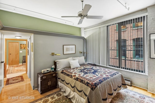 bedroom featuring ceiling fan, rail lighting, and hardwood / wood-style floors