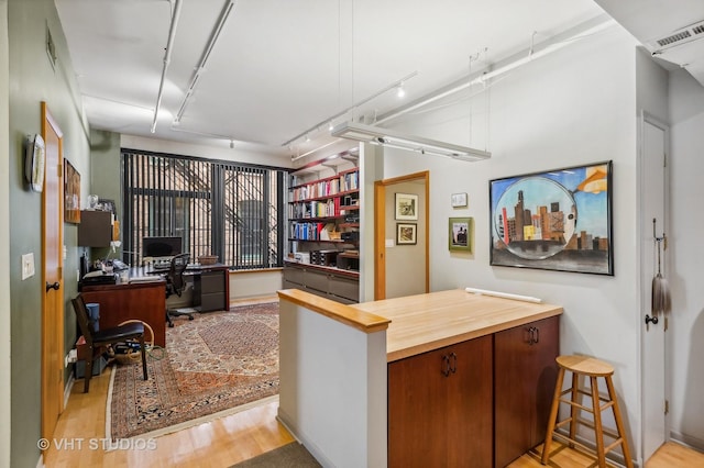 office with track lighting and light wood-type flooring