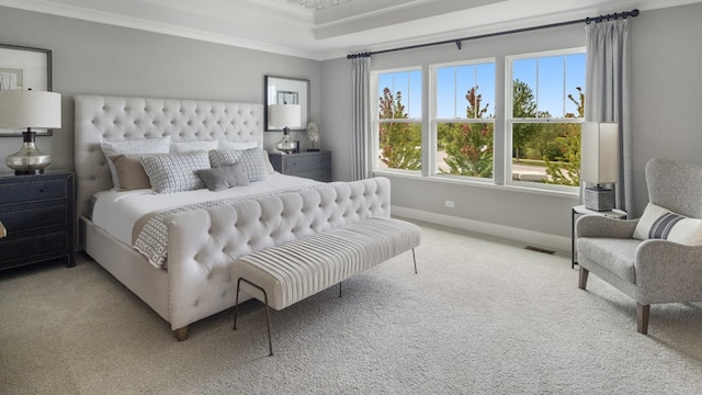 bedroom featuring a raised ceiling, carpet floors, and crown molding