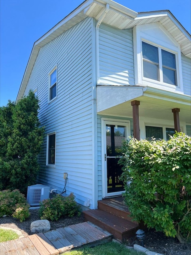 view of side of property with a porch and central AC unit