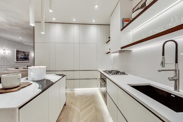 kitchen featuring white cabinetry, light parquet floors, stainless steel appliances, and sink