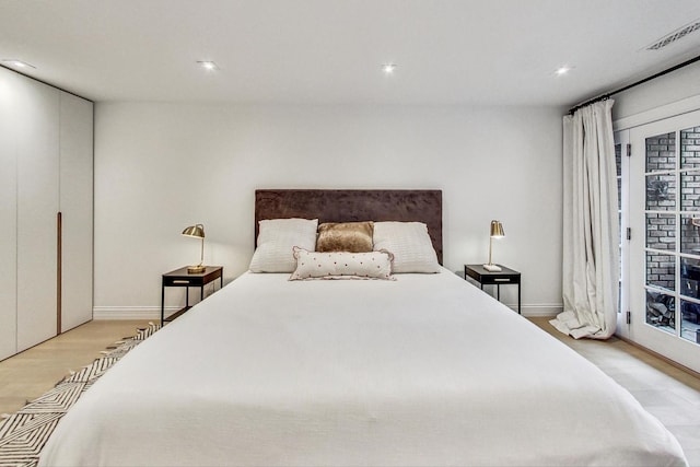 bedroom with access to outside and light hardwood / wood-style flooring