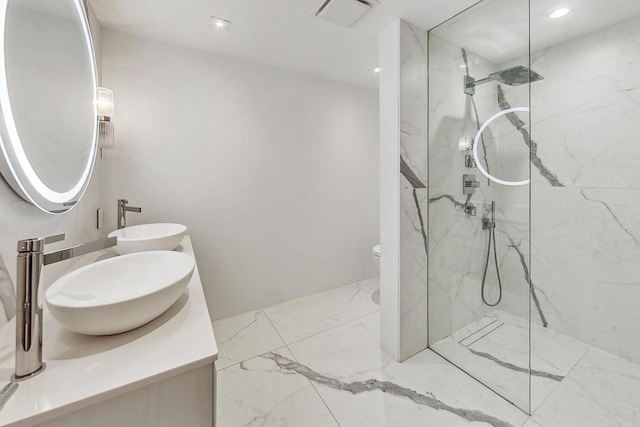 bathroom featuring vanity, toilet, and tiled shower