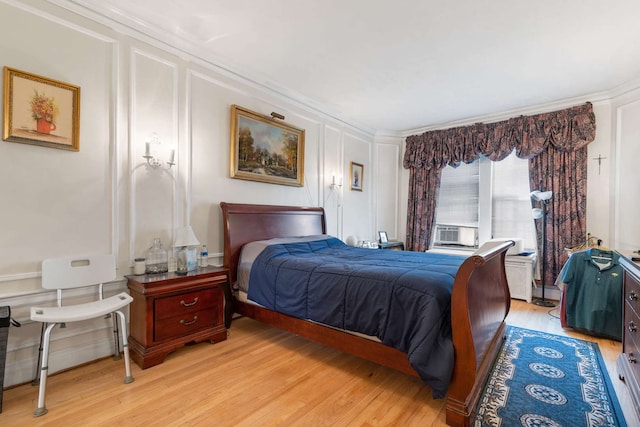 bedroom with light hardwood / wood-style floors and crown molding