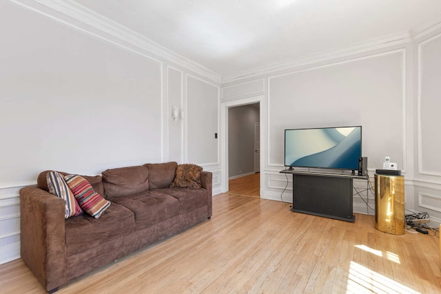 living room featuring light wood-type flooring and crown molding