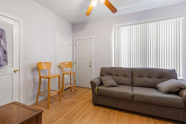 living room with ceiling fan and light hardwood / wood-style flooring