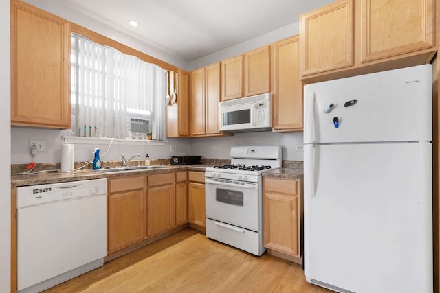 kitchen with sink, light hardwood / wood-style flooring, white appliances, and light brown cabinetry