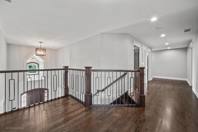 hall with a notable chandelier and dark hardwood / wood-style floors