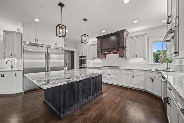 kitchen featuring dark hardwood / wood-style flooring, stainless steel appliances, a kitchen island, and white cabinetry