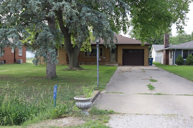 single story home featuring a garage, a front lawn, and central air condition unit