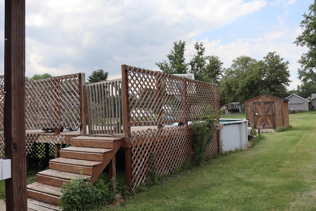 wooden terrace with a shed and a lawn