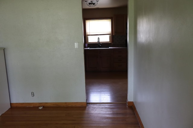 hall with sink and dark wood-type flooring