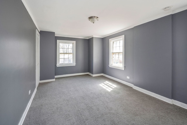 empty room featuring crown molding, plenty of natural light, and carpet flooring