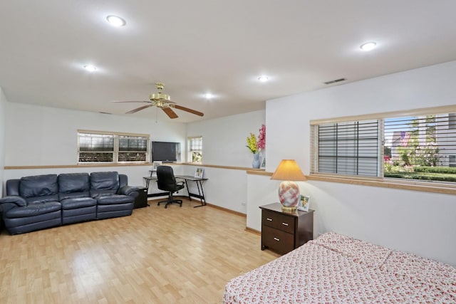 bedroom with ceiling fan, light wood-type flooring, and multiple windows