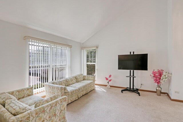 living room featuring high vaulted ceiling and carpet flooring