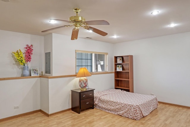 bedroom with light wood-type flooring, electric panel, and ceiling fan