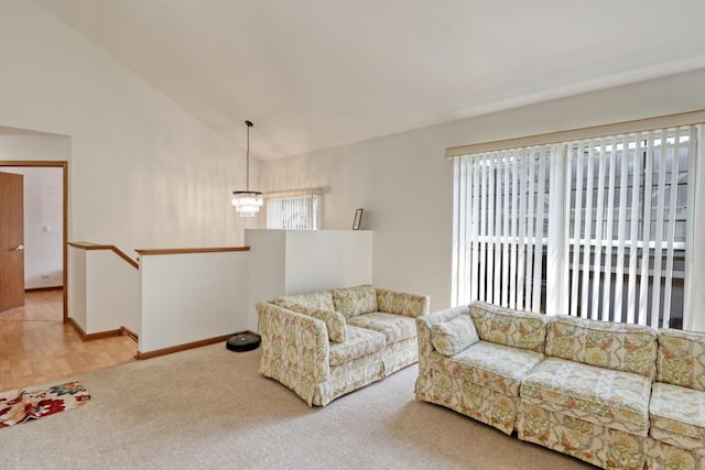 carpeted living room with lofted ceiling, a notable chandelier, and plenty of natural light