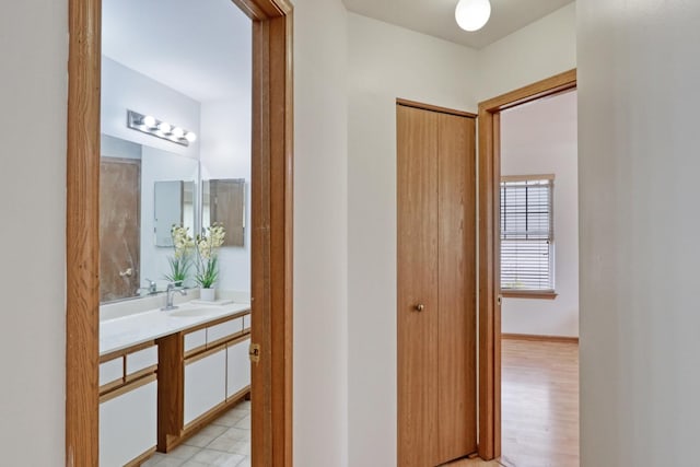 hall with light hardwood / wood-style flooring and sink