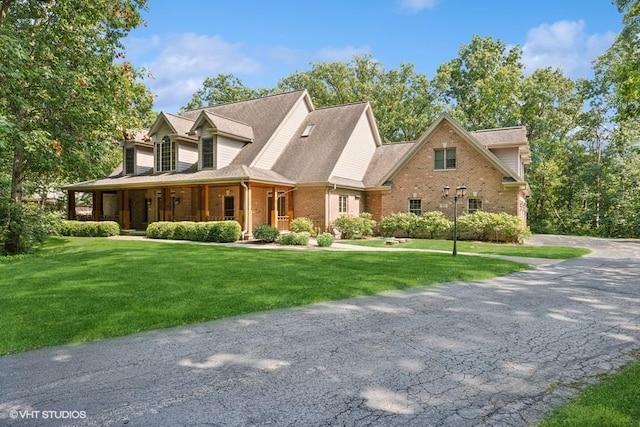 view of front of house featuring covered porch and a front lawn