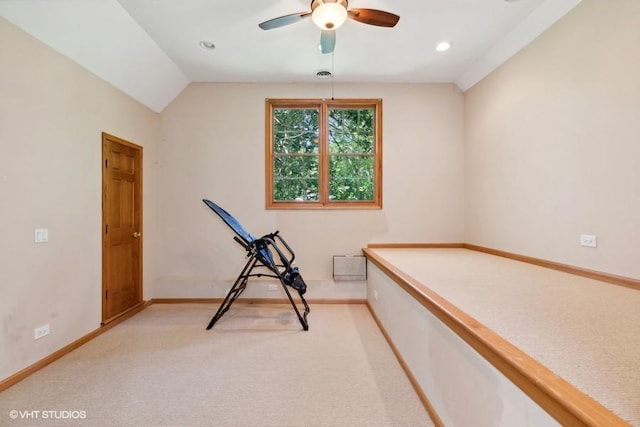 interior space with ceiling fan, lofted ceiling, and light carpet