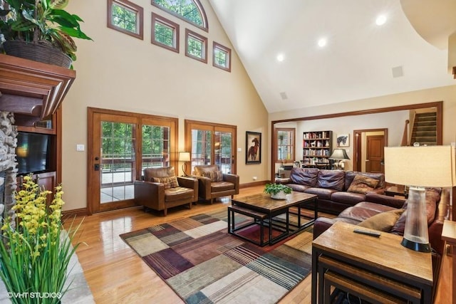 living room with a towering ceiling and light hardwood / wood-style floors