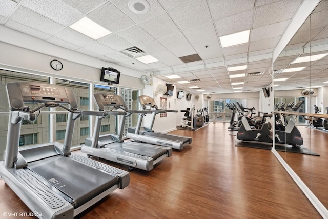 workout area with a drop ceiling and wood-type flooring