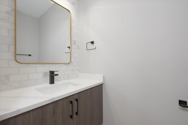 bathroom featuring vanity and tasteful backsplash