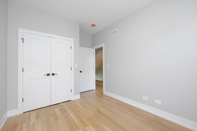 unfurnished bedroom featuring light hardwood / wood-style flooring and a closet