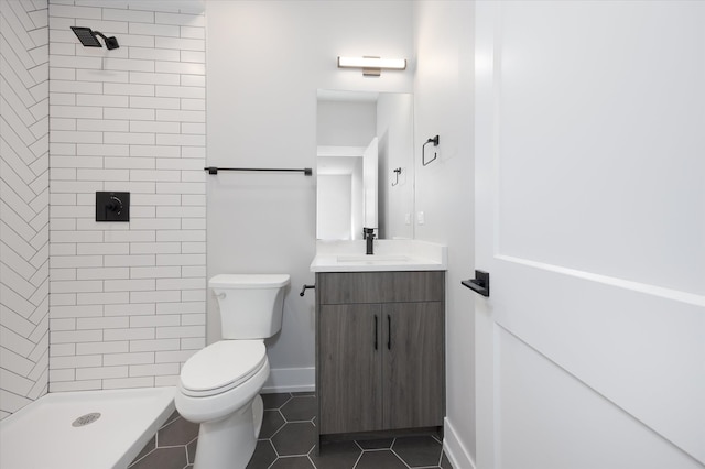 bathroom featuring tile patterned floors, toilet, vanity, and a tile shower