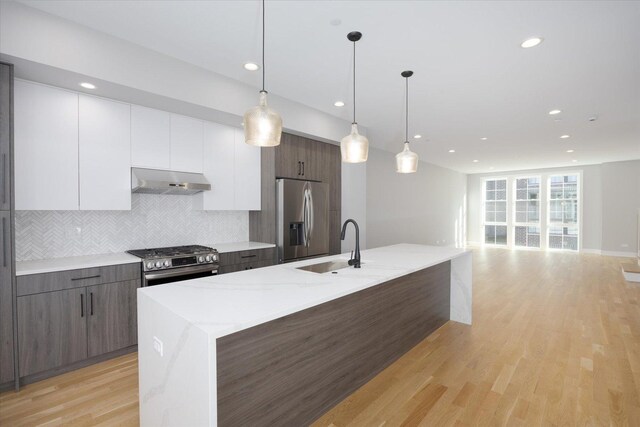 kitchen with dark brown cabinets, white cabinets, pendant lighting, and stainless steel appliances