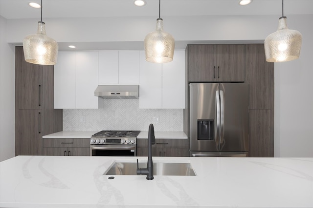 kitchen with white cabinetry, appliances with stainless steel finishes, dark brown cabinetry, and tasteful backsplash