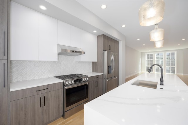 kitchen featuring white cabinets, sink, decorative light fixtures, backsplash, and stainless steel appliances