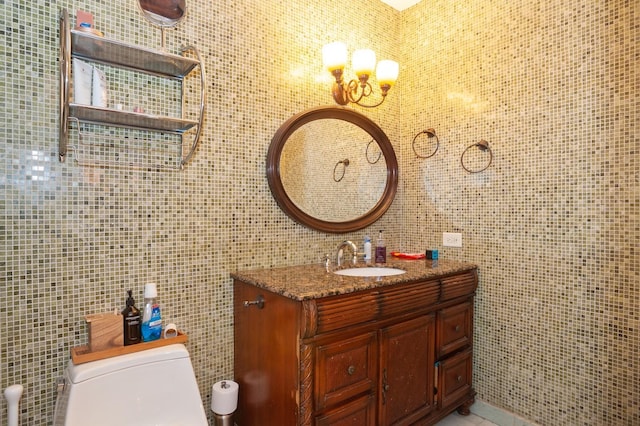 bathroom with vanity, toilet, and tile walls