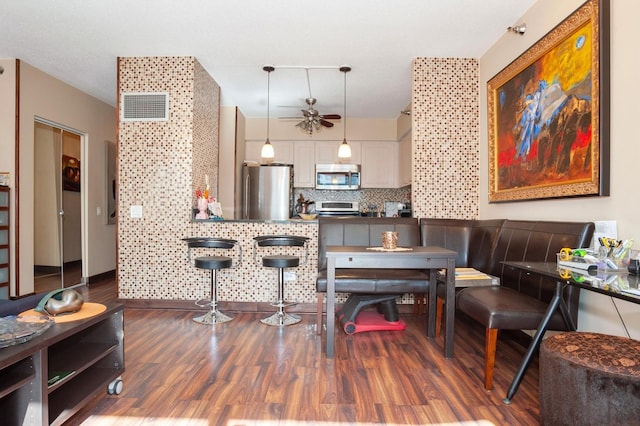 dining space featuring ceiling fan and dark hardwood / wood-style flooring